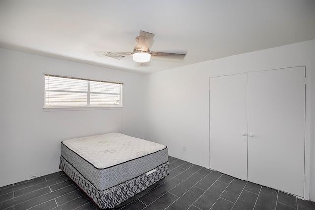 bedroom with ceiling fan, visible vents, and a closet