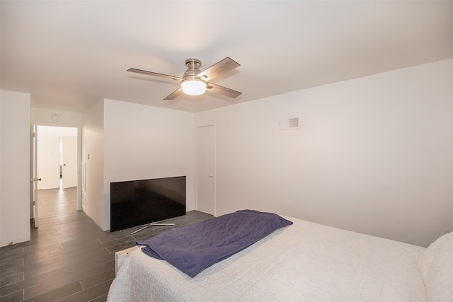 bedroom with dark wood-type flooring, visible vents, and a ceiling fan