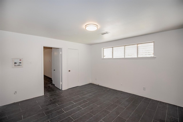 empty room with visible vents and dark wood-type flooring