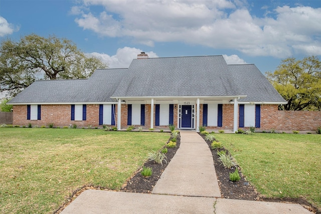 view of front facade with brick siding, roof with shingles, a chimney, and fence