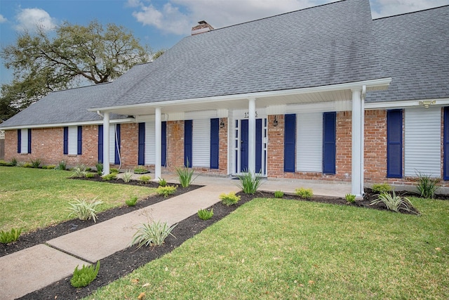 view of front of home with brick siding, roof with shingles, and a chimney