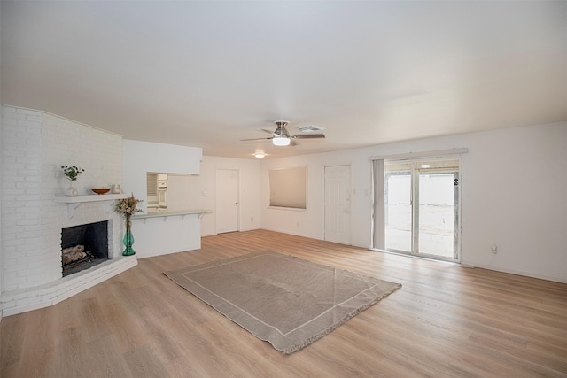 unfurnished living room with a fireplace, light wood-style flooring, visible vents, and ceiling fan
