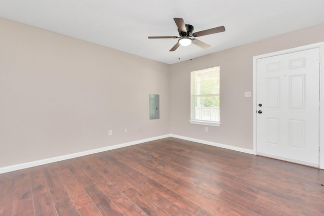unfurnished room featuring baseboards, ceiling fan, electric panel, and dark wood finished floors
