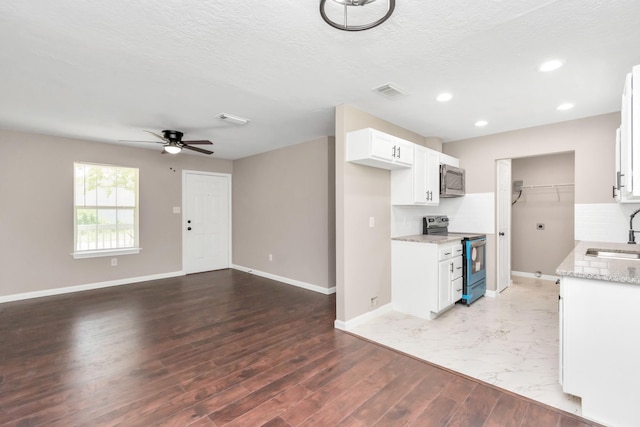 kitchen with ceiling fan, visible vents, a sink, baseboards, and stainless steel appliances
