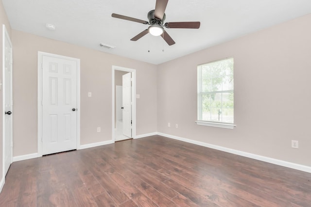 unfurnished bedroom with visible vents, dark wood finished floors, ceiling fan, and baseboards