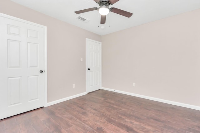 unfurnished bedroom with dark wood-style flooring, baseboards, visible vents, and a ceiling fan