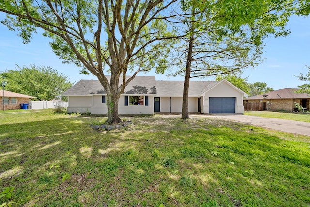 view of front of property with concrete driveway, a front lawn, fence, and an attached garage