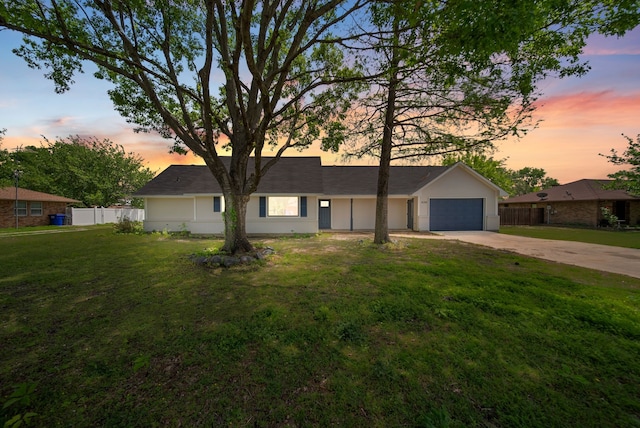 single story home with an attached garage, driveway, fence, and a lawn