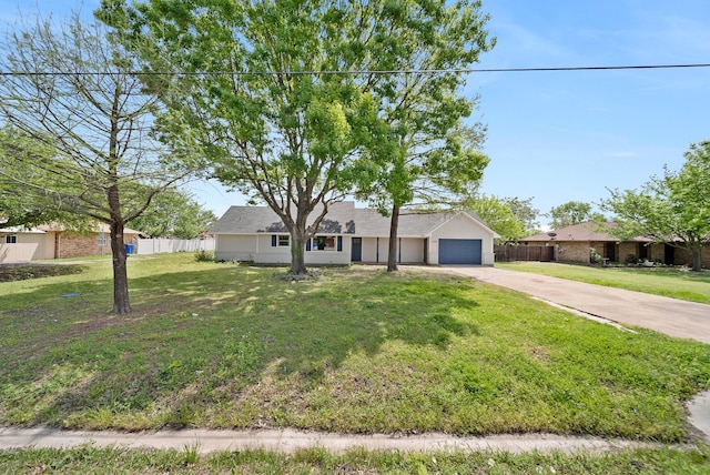 ranch-style home with an attached garage, fence, driveway, and a front lawn