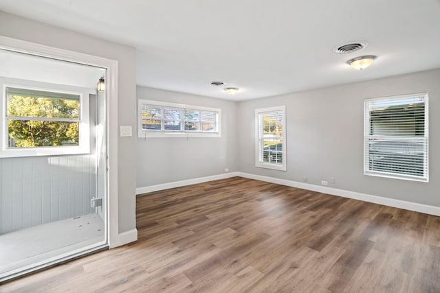 unfurnished room with visible vents, baseboards, and wood finished floors