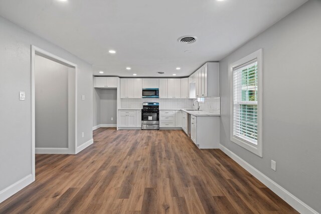 kitchen featuring visible vents, baseboards, a sink, decorative backsplash, and appliances with stainless steel finishes