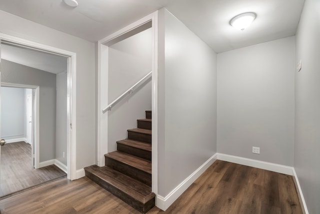 stairs with wood finished floors and baseboards
