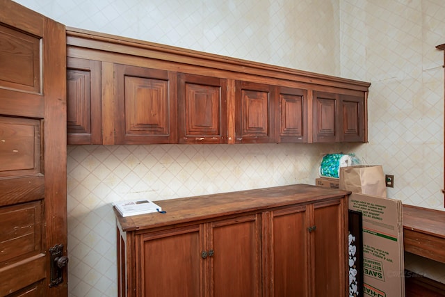 406 7th St, Sealy, TX 77474 - kitchen featuring butcher block counters, brown cabinetry, and wallpapered walls