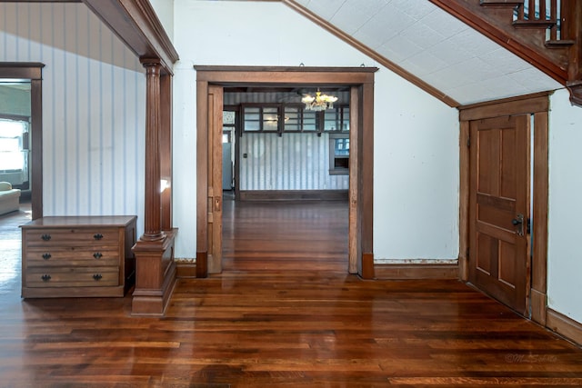 406 7th St, Sealy, TX 77474 - hallway with lofted ceiling, dark wood-style flooring, ornate columns, and an inviting chandelier