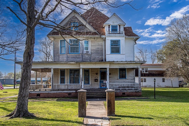 406 7th St, Sealy, TX 77474 - victorian-style house featuring a porch, crawl space, a front lawn, and cooling unit