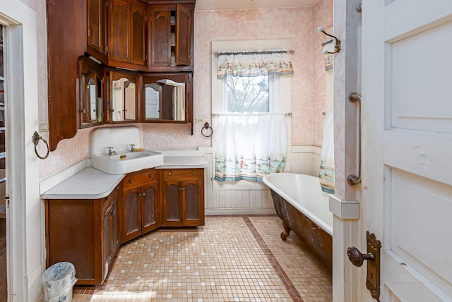406 7th St, Sealy, TX 77474 - bathroom with wallpapered walls, tile patterned floors, vanity, wainscoting, and a freestanding tub
