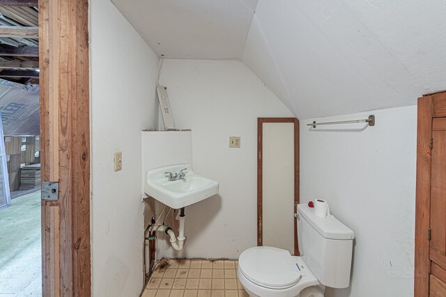 406 7th St, Sealy, TX 77474 - bathroom with lofted ceiling, a sink, and toilet