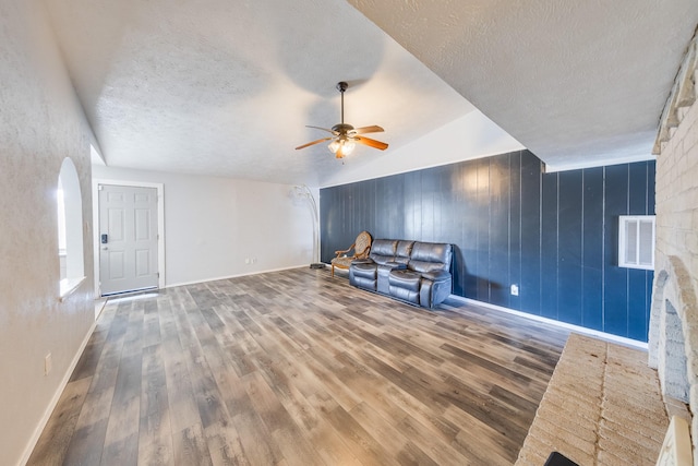 14106 Meyersville Dr, Houston, TX 77049 - unfurnished living room with ceiling fan, arched walkways, wood finished floors, baseboards, and a textured ceiling
