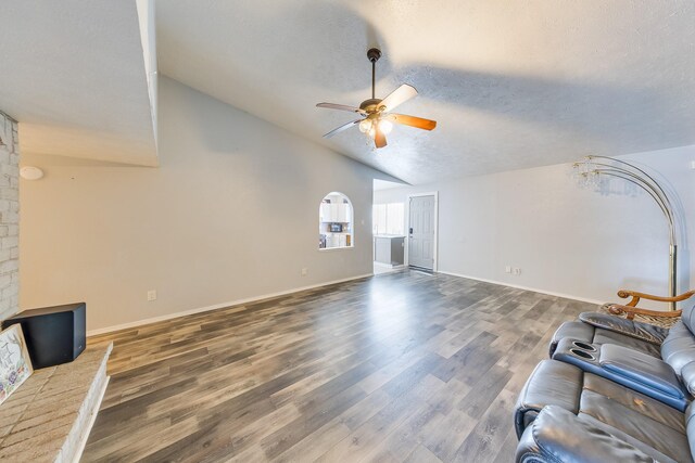 14106 Meyersville Dr, Houston, TX 77049 - unfurnished living room with ceiling fan, vaulted ceiling, wood finished floors, a textured ceiling, and baseboards