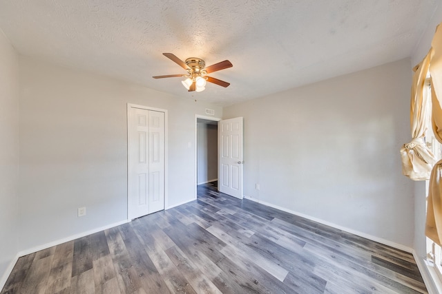 14106 Meyersville Dr, Houston, TX 77049 - unfurnished bedroom featuring dark wood finished floors, baseboards, a closet, ceiling fan, and a textured ceiling