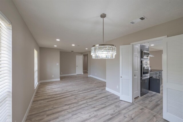 9315 Fairdale Ln, Houston, TX 77063 - unfurnished dining area with light wood-type flooring, baseboards, a chandelier, and recessed lighting
