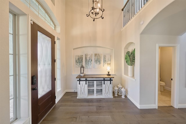 120 Shane St, Montgomery, TX 77316 - foyer entrance featuring a high ceiling, wood finished floors, a chandelier, baseboards, and arched walkways