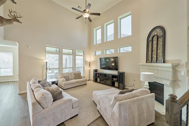 120 Shane St, Montgomery, TX 77316 - living room with a high ceiling, a premium fireplace, a ceiling fan, wood finished floors, and baseboards