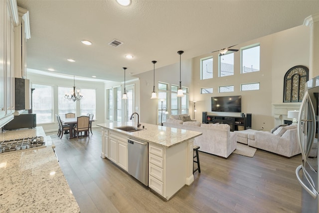120 Shane St, Montgomery, TX 77316 - kitchen with appliances with stainless steel finishes, a sink, wood finished floors, a kitchen breakfast bar, and light stone countertops