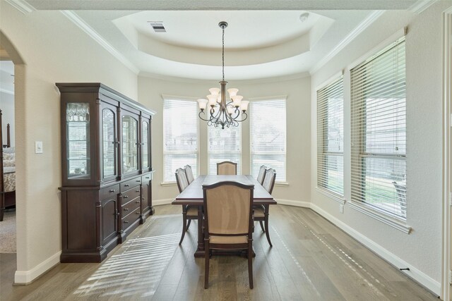 120 Shane St, Montgomery, TX 77316 - dining room with a raised ceiling, light wood-type flooring, arched walkways, a chandelier, and baseboards