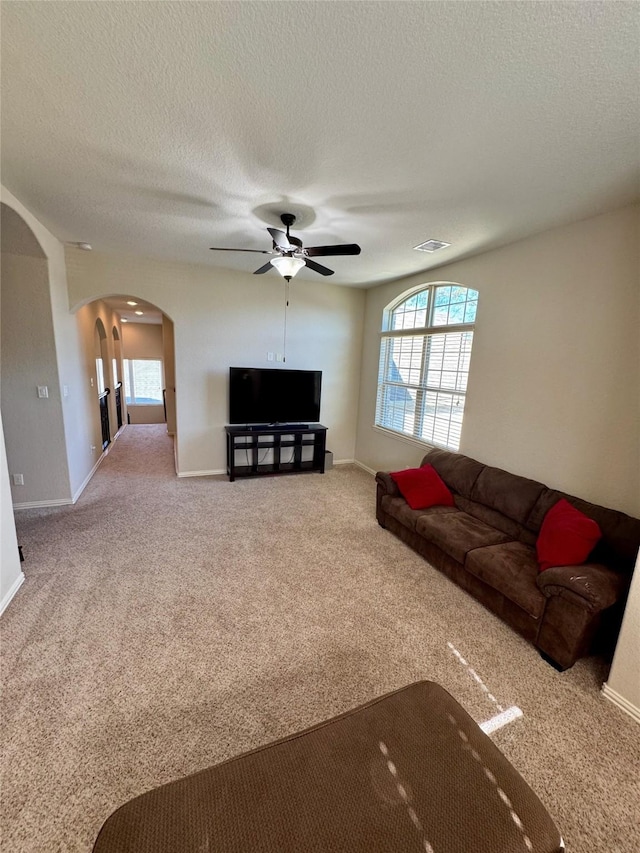 120 Shane St, Montgomery, TX 77316 - living area with arched walkways, carpet flooring, ceiling fan, and a textured ceiling