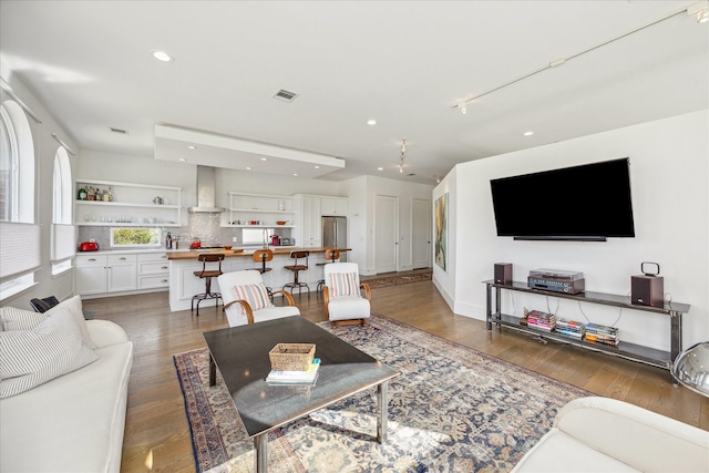 living room with recessed lighting, light wood finished floors, and visible vents