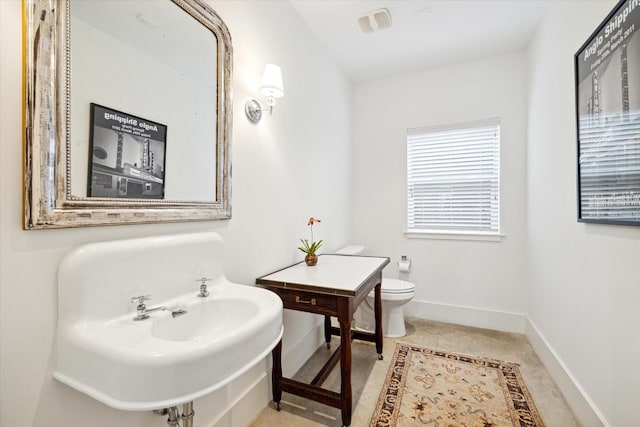 bathroom featuring visible vents, baseboards, and toilet