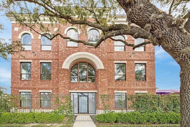 exterior space featuring brick siding and a fenced front yard