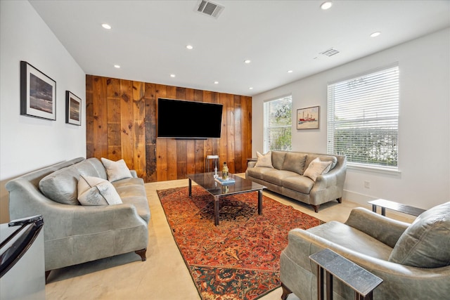 living room featuring wood walls, recessed lighting, and visible vents