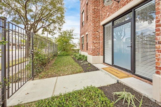 exterior space with fence and brick siding
