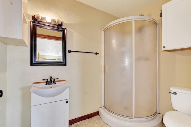 bathroom with vanity, tile patterned flooring, a shower stall, and toilet