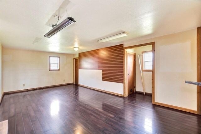 spare room with dark wood finished floors and baseboards
