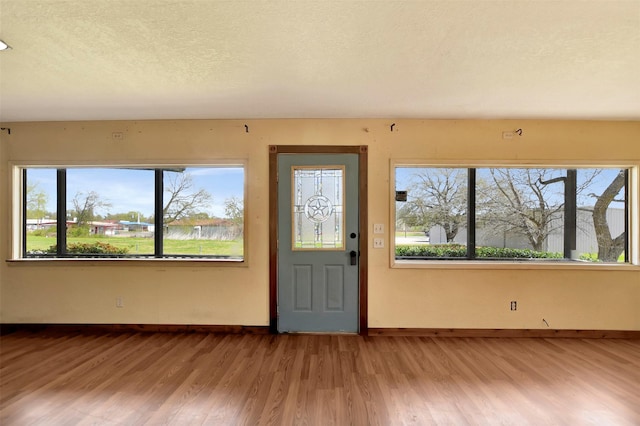 301 Price St, Madisonville, TX 77864 - foyer entrance featuring baseboards, wood finished floors, and a textured ceiling