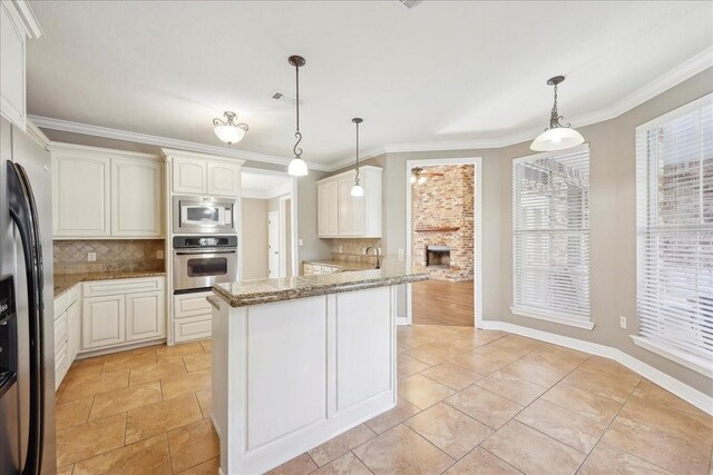 7403 S Park Rd, Lumberton, TX 77657 - kitchen featuring visible vents, stainless steel appliances, pendant lighting, crown molding, and tasteful backsplash