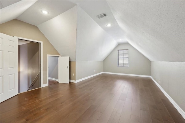 7403 S Park Rd, Lumberton, TX 77657 - bonus room featuring visible vents, a textured ceiling, dark wood-style floors, and vaulted ceiling