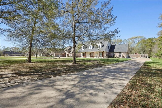 7403 S Park Rd, Lumberton, TX 77657 - new england style home featuring concrete driveway, a front lawn, and stone siding
