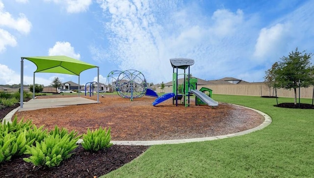 community play area with fence and a lawn