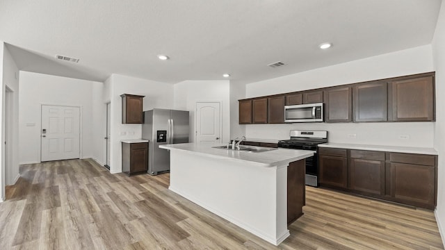 kitchen featuring light wood-type flooring, appliances with stainless steel finishes, a sink, and visible vents