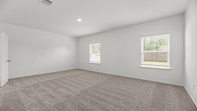 carpeted empty room featuring visible vents, baseboards, and recessed lighting
