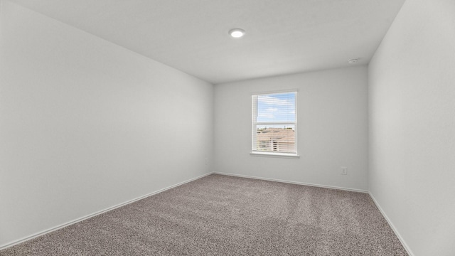 carpeted empty room with baseboards