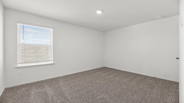 spare room featuring recessed lighting, baseboards, and carpet floors