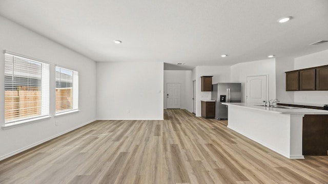 kitchen with stainless steel fridge, recessed lighting, light wood-style flooring, light countertops, and visible vents