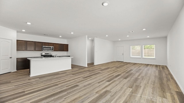 kitchen with open floor plan, light wood-type flooring, appliances with stainless steel finishes, and recessed lighting