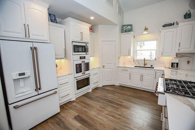kitchen featuring white appliances, white cabinets, and a sink