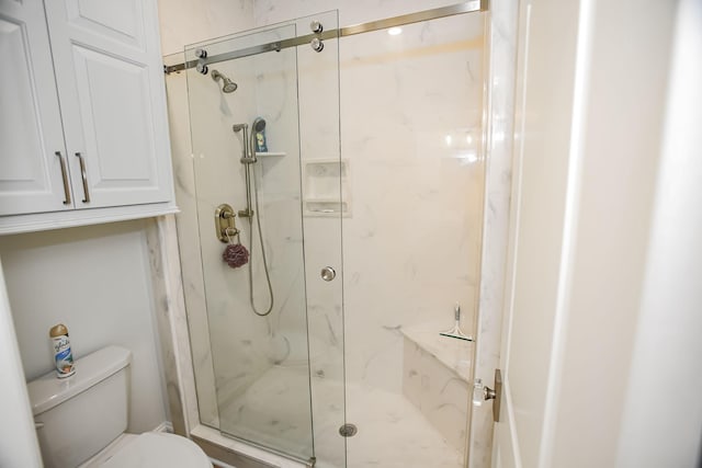 full bath with a marble finish shower and toilet